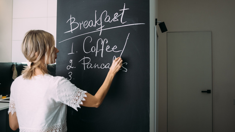 woman writing on chalk wall