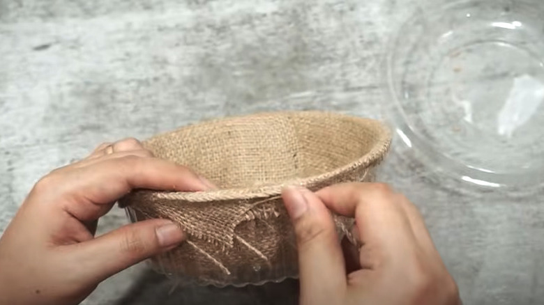 wrapping plastic container in twine