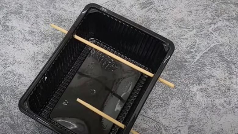 bamboo chopsticks through plastic container