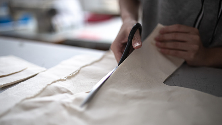 Hands cutting fabric with scissors