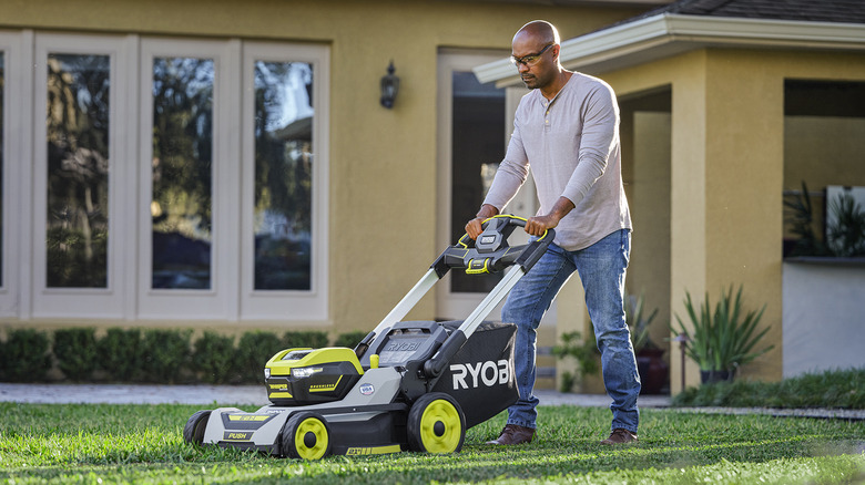 Bald man mowing lawn