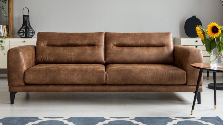 Brown leather couch with sunflowers