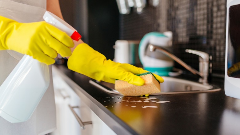 Spraying countertop to clean it