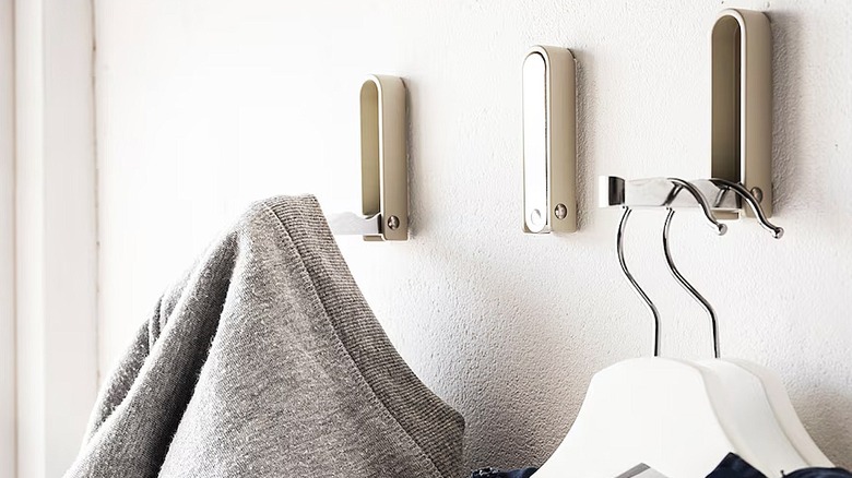 IKEA KLYKET folding hooks attached to a wall with clothes hanging