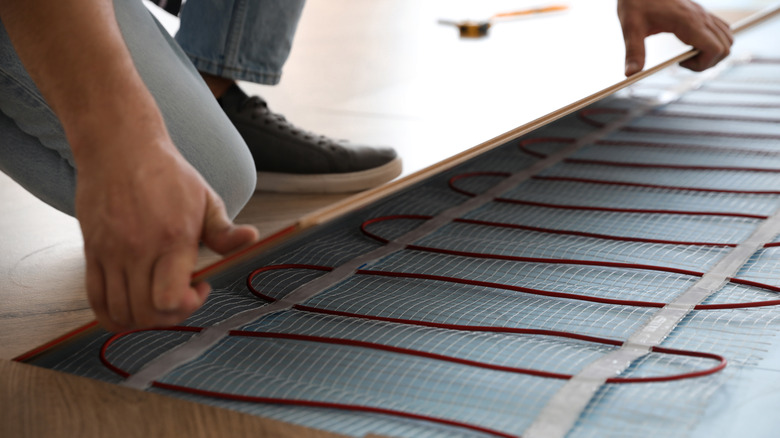 Person installing in-floor heating system