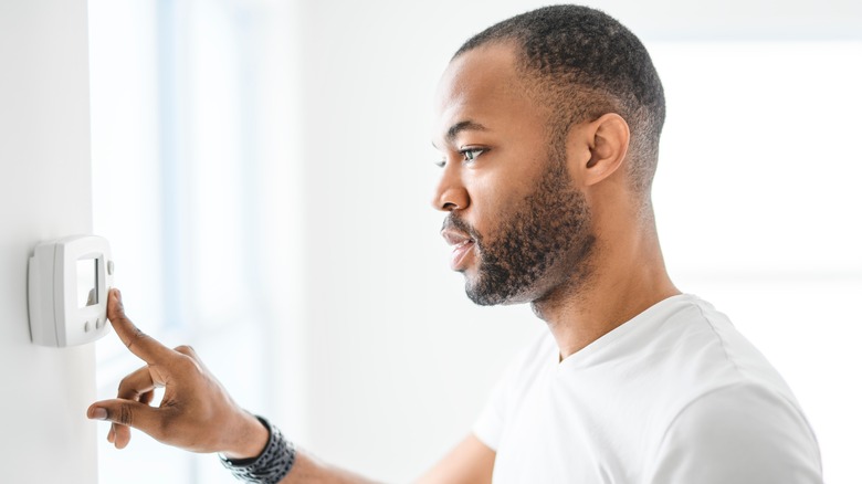 Man adjusting the thermostat