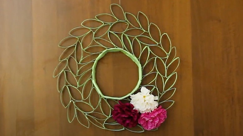 A green leaf wreath with red, pink and white flowers on one side