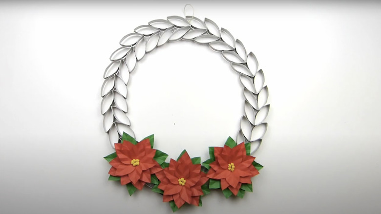 A leaf and flower wreath made from toilet paper rolls.