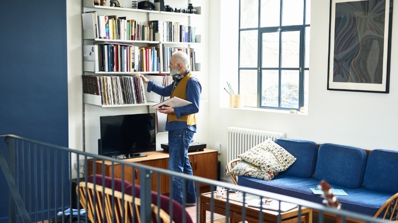 A man stands in a stylish loft looking at records.