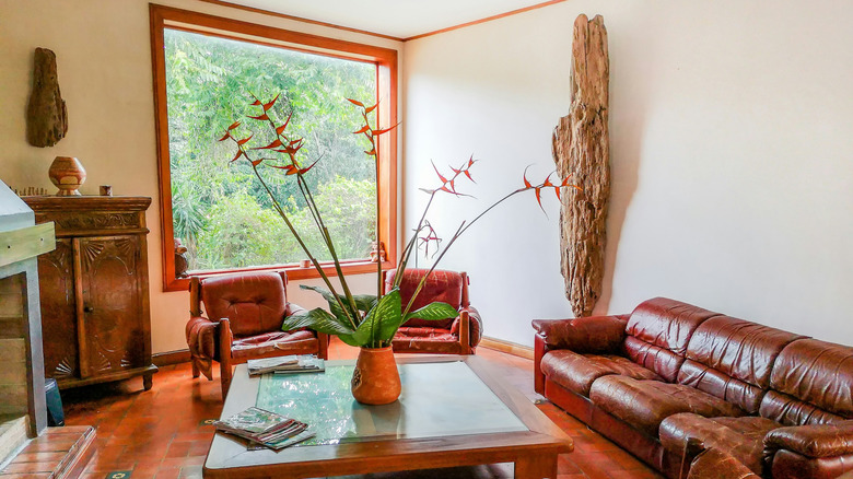 A warmly decorated room with dark red couches, ruby-red floors, and warm brown cabinets.