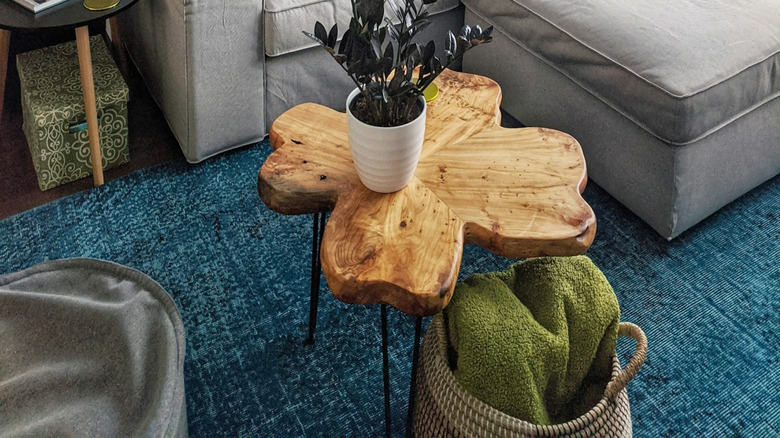 A grey couch with modern decor and a deep blue rug.