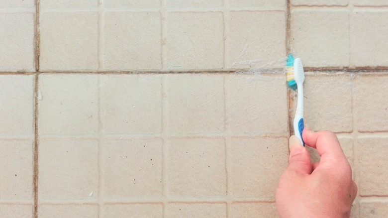 Cleaning grout with toothbrush