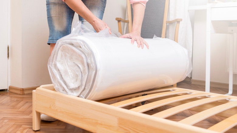 woman rolling out mattress 