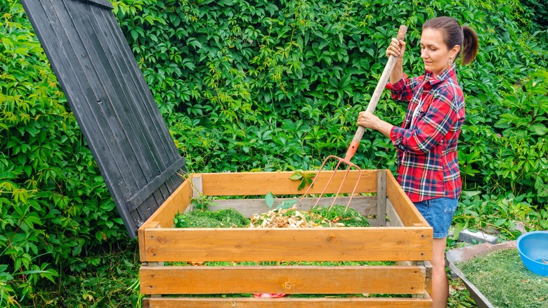 Person mixing a compost pile