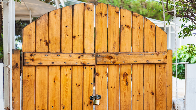 Vintage wooden double fence gate with a padlock