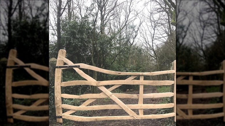 Curvy wooden fence gate with trees in the background