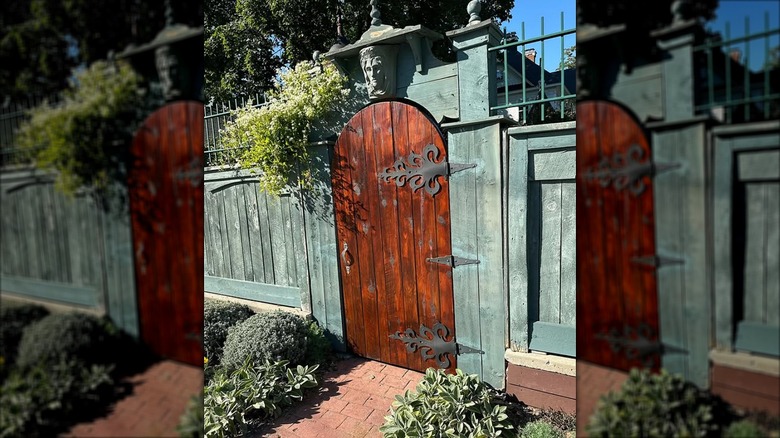 Beautiful fence gate with a statue above it