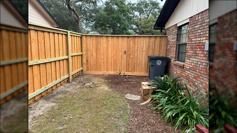 Picture of a yard next to a house with a fence and a hidden fence gate