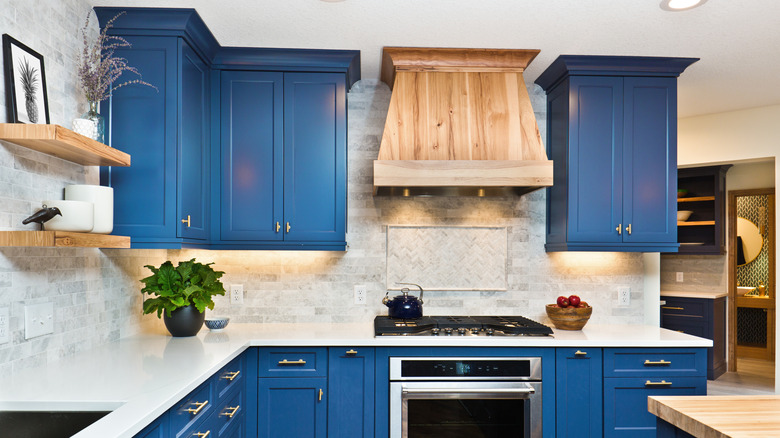 Deep blue cabinets in a kitchen with white and wood accents