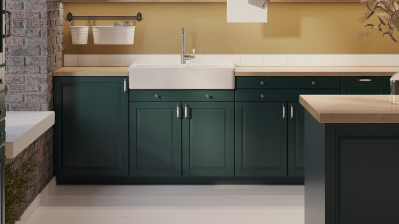 Kitchen with green cabinets and taupe walls