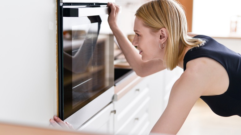 Woman checking the oven