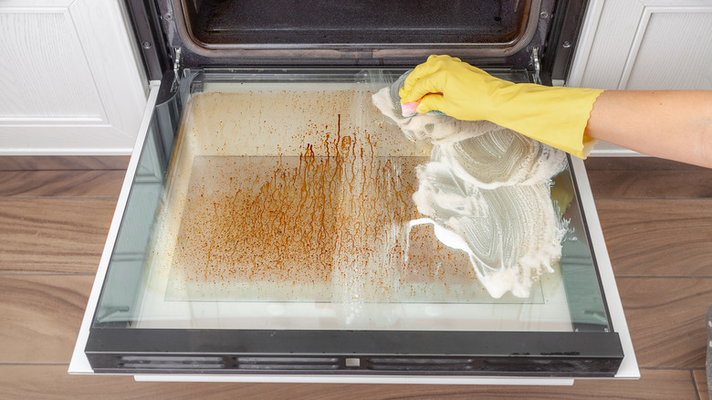Scrubbing a dirty oven window