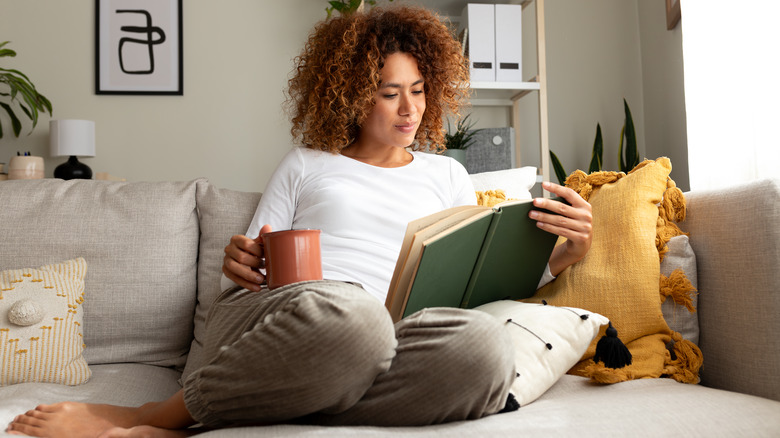 Woman reads holding a coffee