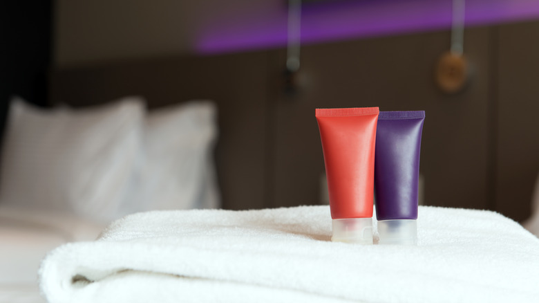 Toiletry essentials on folded towels in a guest bedroom