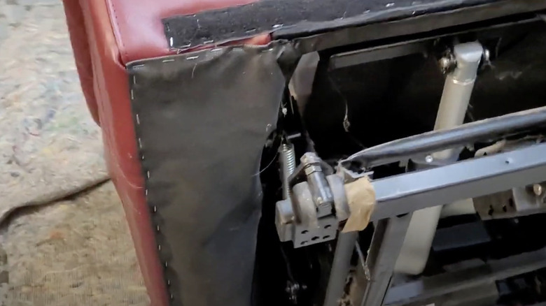 A steel tension spring in the footrest of a recliner chair.