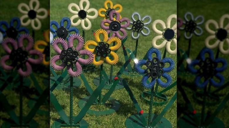 Metal flower garden art made from trampoline springs and scrap metal spray painted various colors.