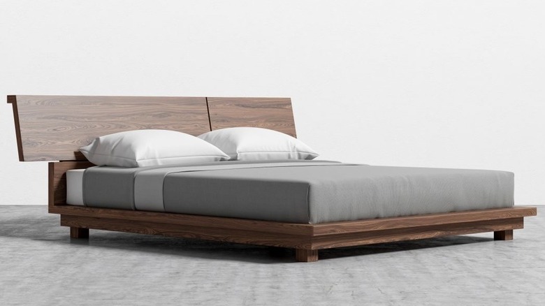 Modern dark wood platform bed in a white room