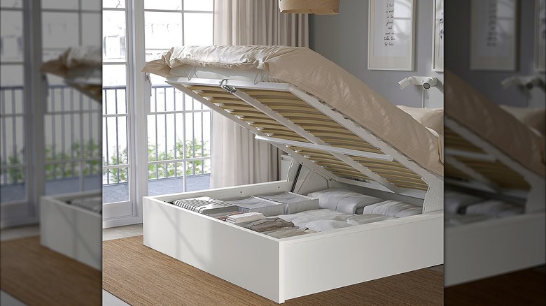 White IKEA storage bed with the top lifted up