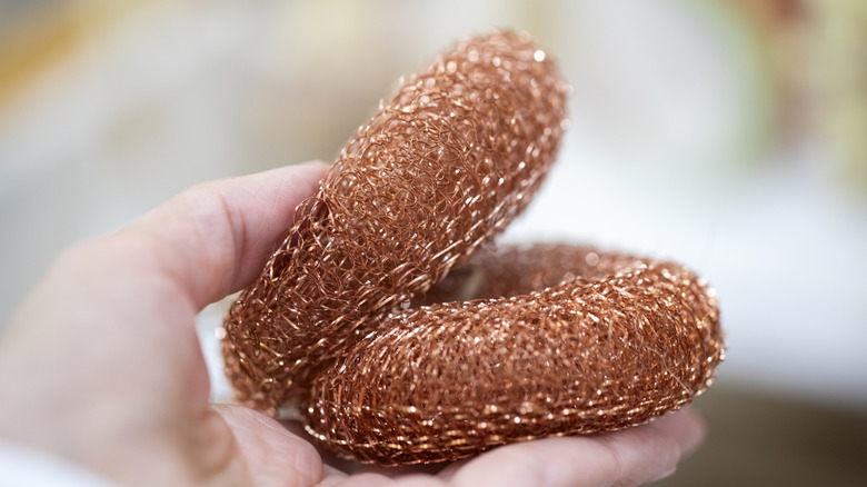 close-up of copper scrubbers in a hand