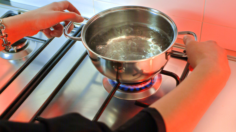 Person boiling water on stove