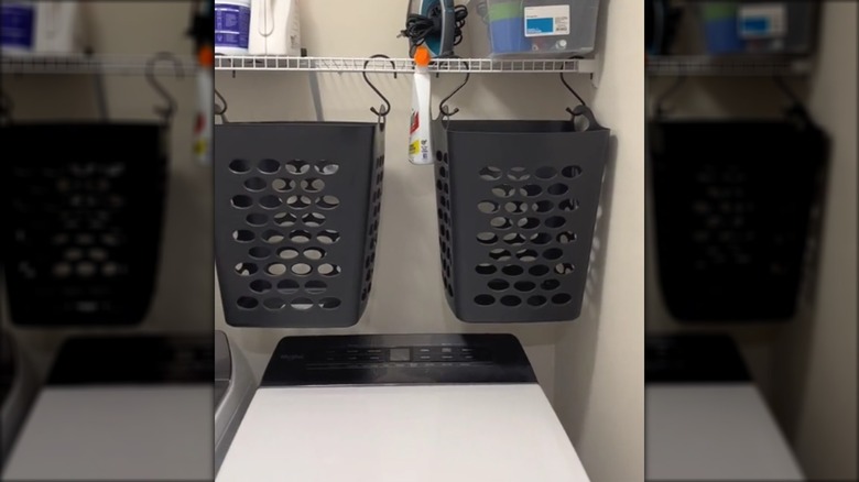 Laundry baskets hanging from a shelf with S-hooks above the laundry machine