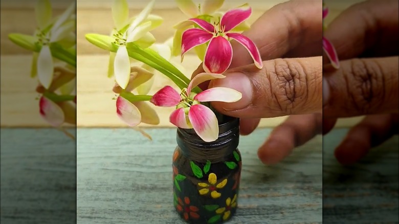 Placing flowers into a prescription bottle vase