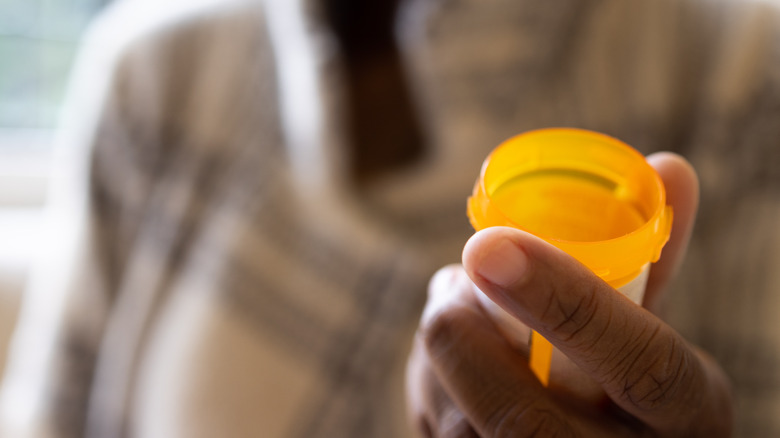 Person holding an empty prescription medication bottle