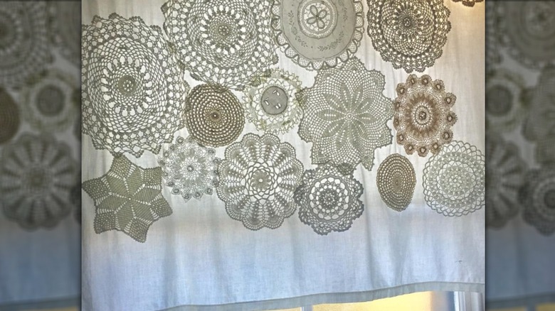 White curtain in window with doilies stitched together in front