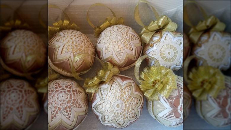 Ornaments covered in doilies with gold ribbons and bows