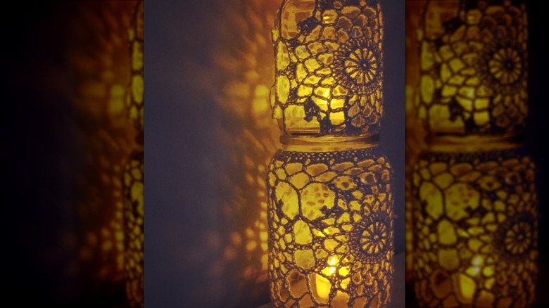 Jar lanterns covered in doilies lit with candles