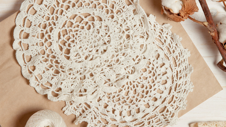 Two vintage doilies on brown paper with twine