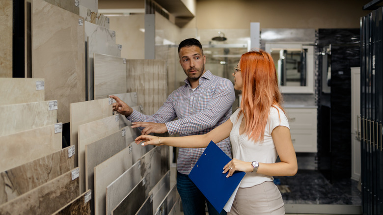 Man choosing ceramic tiles with seller