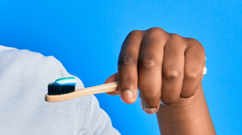 Hand holding toothbrush