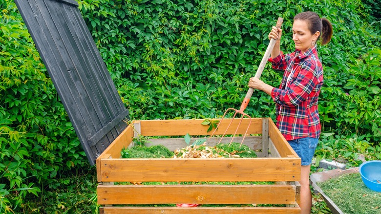 woman mixing a compost pile