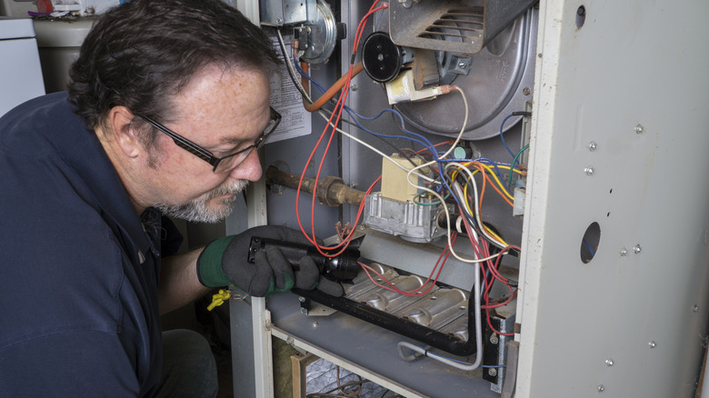 technician inspecting a furnace