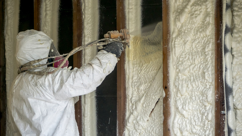 worker applying spray foam insulation