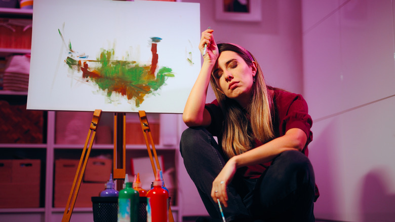 A woman in front of an unfinished painting