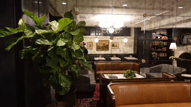 Fiddle leaf fig in front of a smoky mirror wall in Hotel 1928