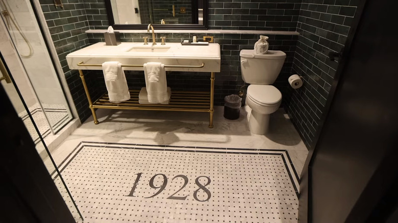 A bathroom in Hotel 1928 with mosaic floor and green subway tiles