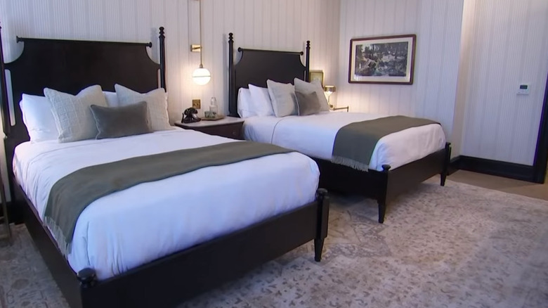 Two black Chippendale-style beds with white linen in Hotel 1928